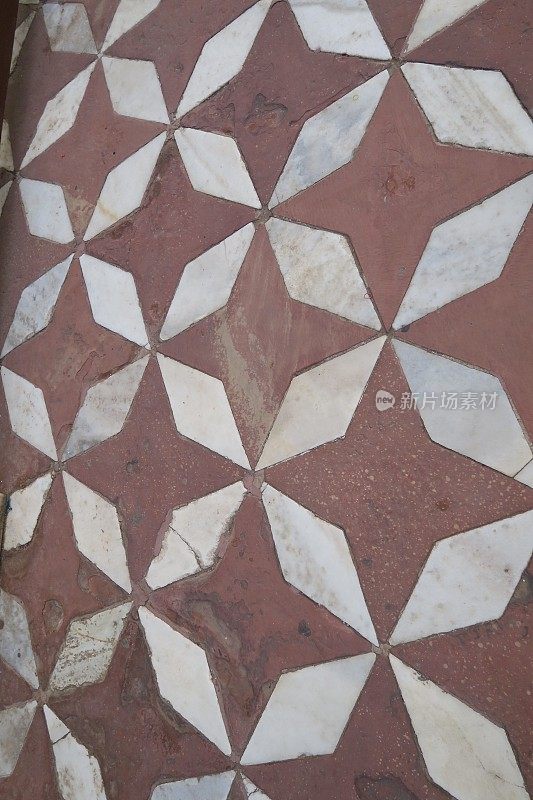 在印度阿格拉的泰姬陵附近，印度的八角形瓷砖地板与味精或镶嵌在红橙色粘土瓷砖形成几何图案和星形/八角形